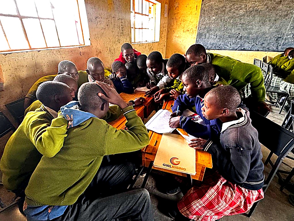 Children studying at wooden desks in a restored classroom in Kenya